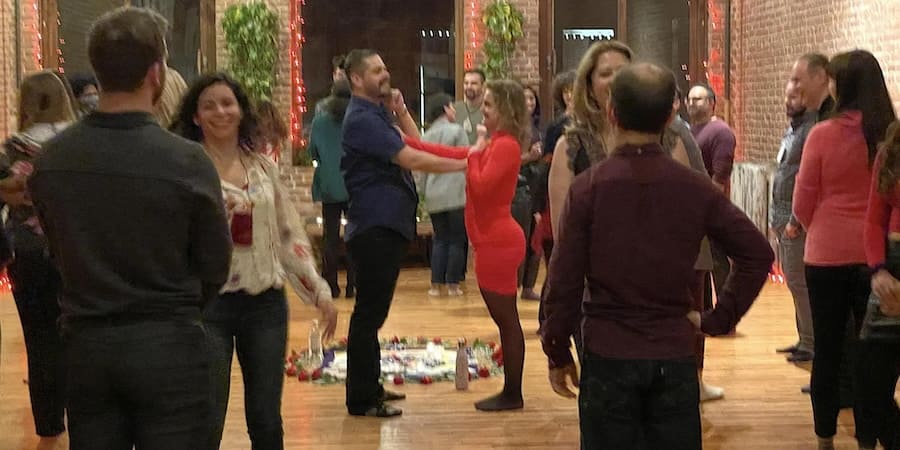 Tantra Speed Dating photo of group of singles observing the facilitator demonstrate an attunement exercise.