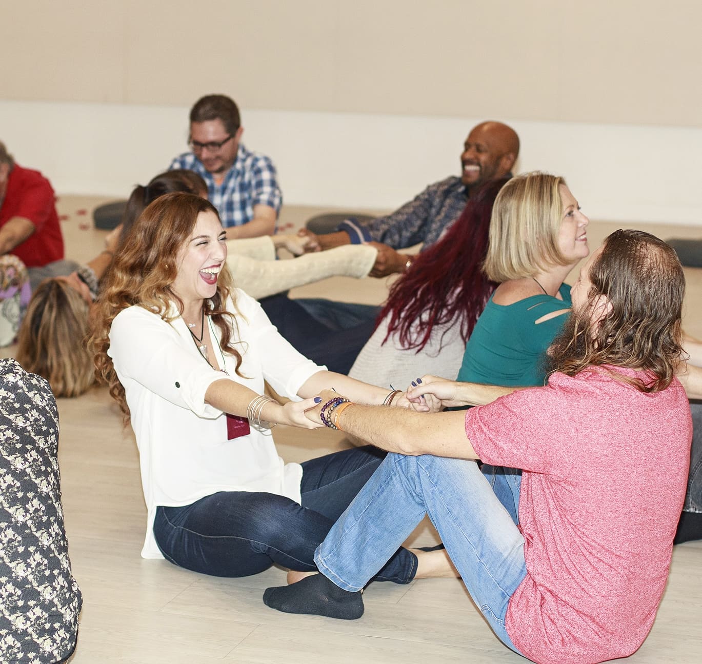 Singles laughing together during a guided connection exercise at a Tantra Speed Date event.